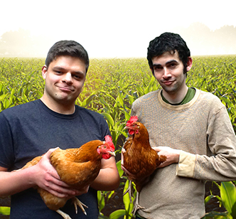 Photo of Ben and Mike holding some chickens in a cornfield