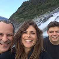 Image may contain: 3 people, people smiling, mountain, sky, outdoor, water and nature